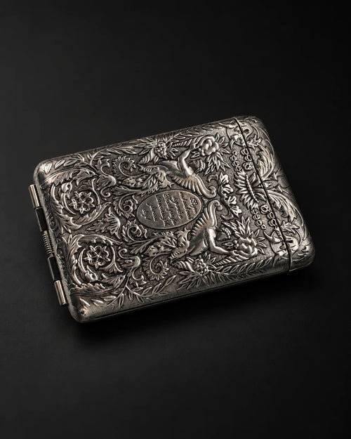 Mozane No. 1, embossed silver-tone metal case on a dark background